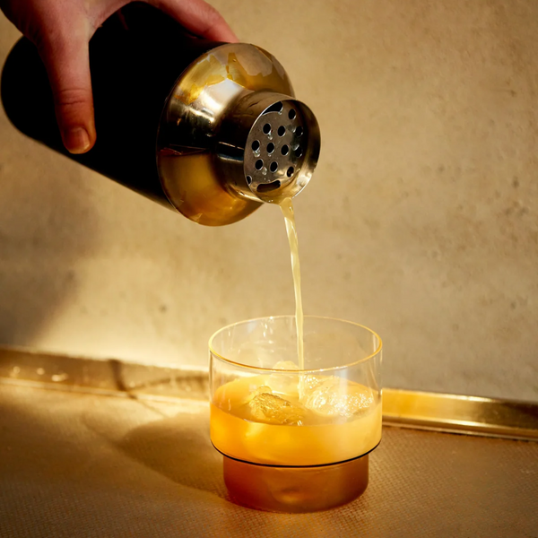 Alcohol free cocktail being poured from a shaker into a glass with ice